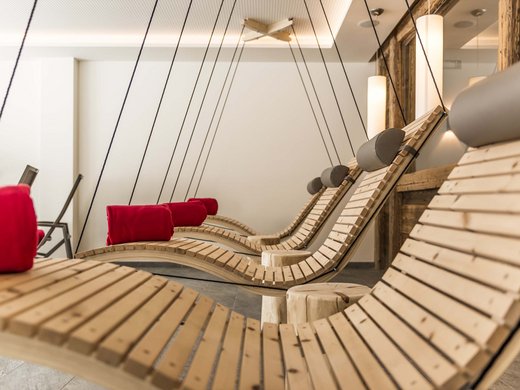 Pflerschtal: accommodation for biking holidays Hanging wooden loungers with red cushions in a modern relaxation room