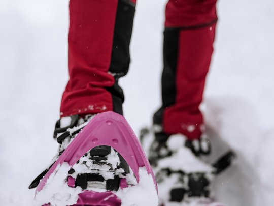 Familienhotel in Sterzing: hoi und herzlich willkommen! Person mit Schneeschuhen und roter Outdoorhose im Schnee