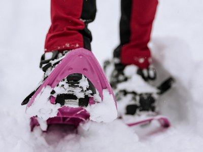 Hotel in Ladurns – perfekt für den Winterurlaub! Person mit Schneeschuhen und roter Outdoorhose im Schnee