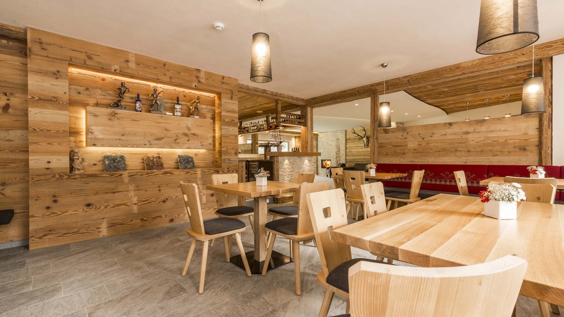 Familienhotel in Sterzing: hoi und herzlich willkommen! Gemütlicher moderner Gastraum mit Holzmöbeln und warmem Licht