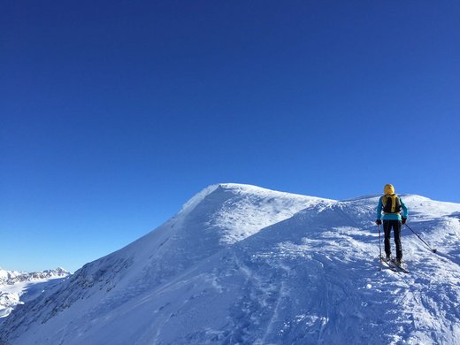 Hotel in Ladurns – perfekt für den Winterurlaub! Skifahrer in gelber Jacke fährt auf schneebedecktem Berg bei klarem blauem Himmel