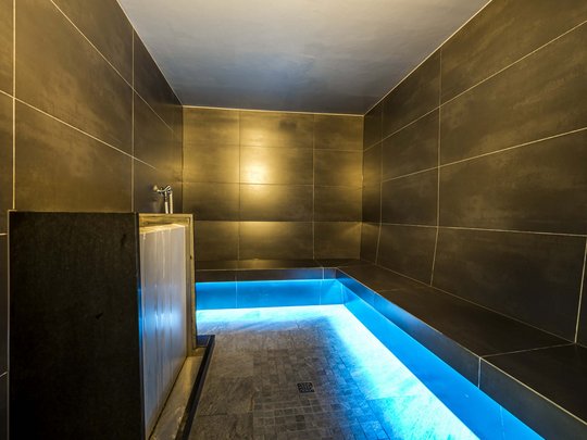 Familienhotel in Sterzing: hoi und herzlich willkommen! Moderner Dampfbadraum mit schwarzer Fliesenwand und blauer LED-Beleuchtung