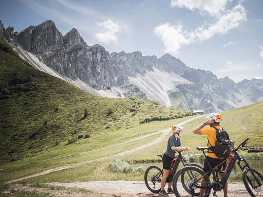 Pflerschtal: accommodation for biking holidays Two cyclists with helmets in front of inviting mountains and green valley