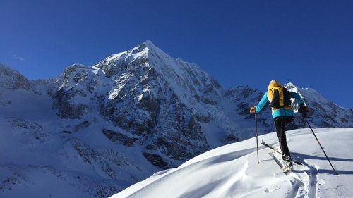 Familienhotel in Sterzing: hoi und herzlich willkommen! Skifahrer beim Aufstieg auf schneebedecktem Berg unter klarem blauem Himmel